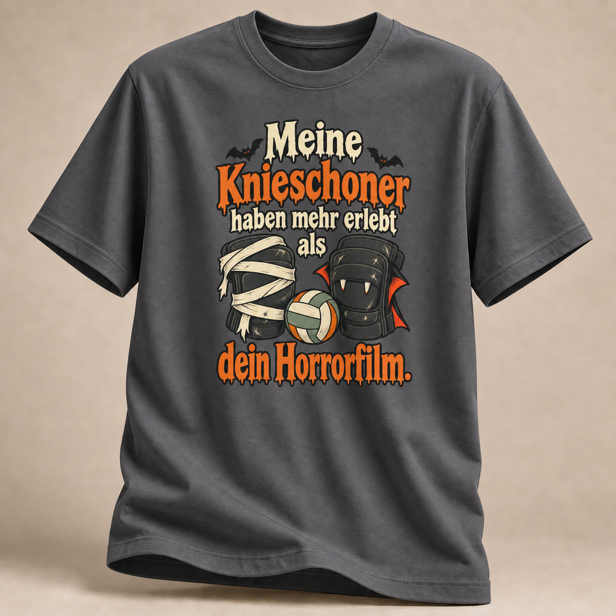 Frontansicht eines anthrazitfarbenen T-Shirts: Mumien- und Vampir-Knieschoner mit Volleyball.