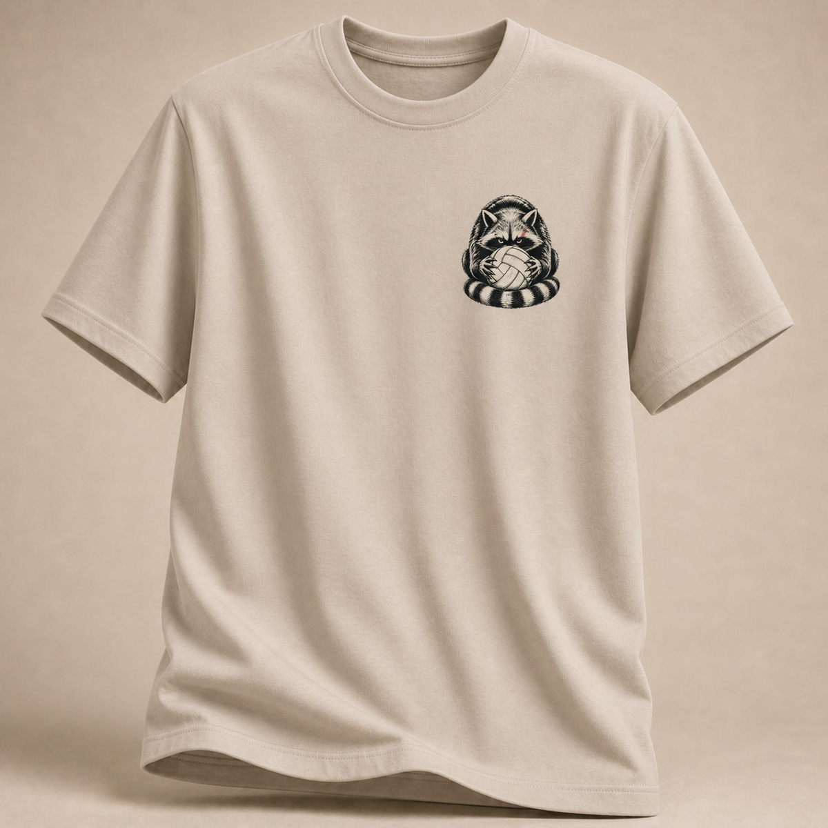 Waschbär mit Volleyball als Brustprint auf sandfarbenem T-Shirt