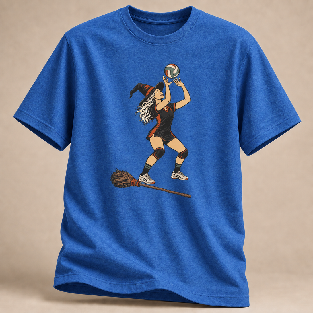 Frontansicht eines königsblau melierten T-Shirts: Hexe beim Zuspiel mit Volleyball und Besen im Halloween-Motiv.