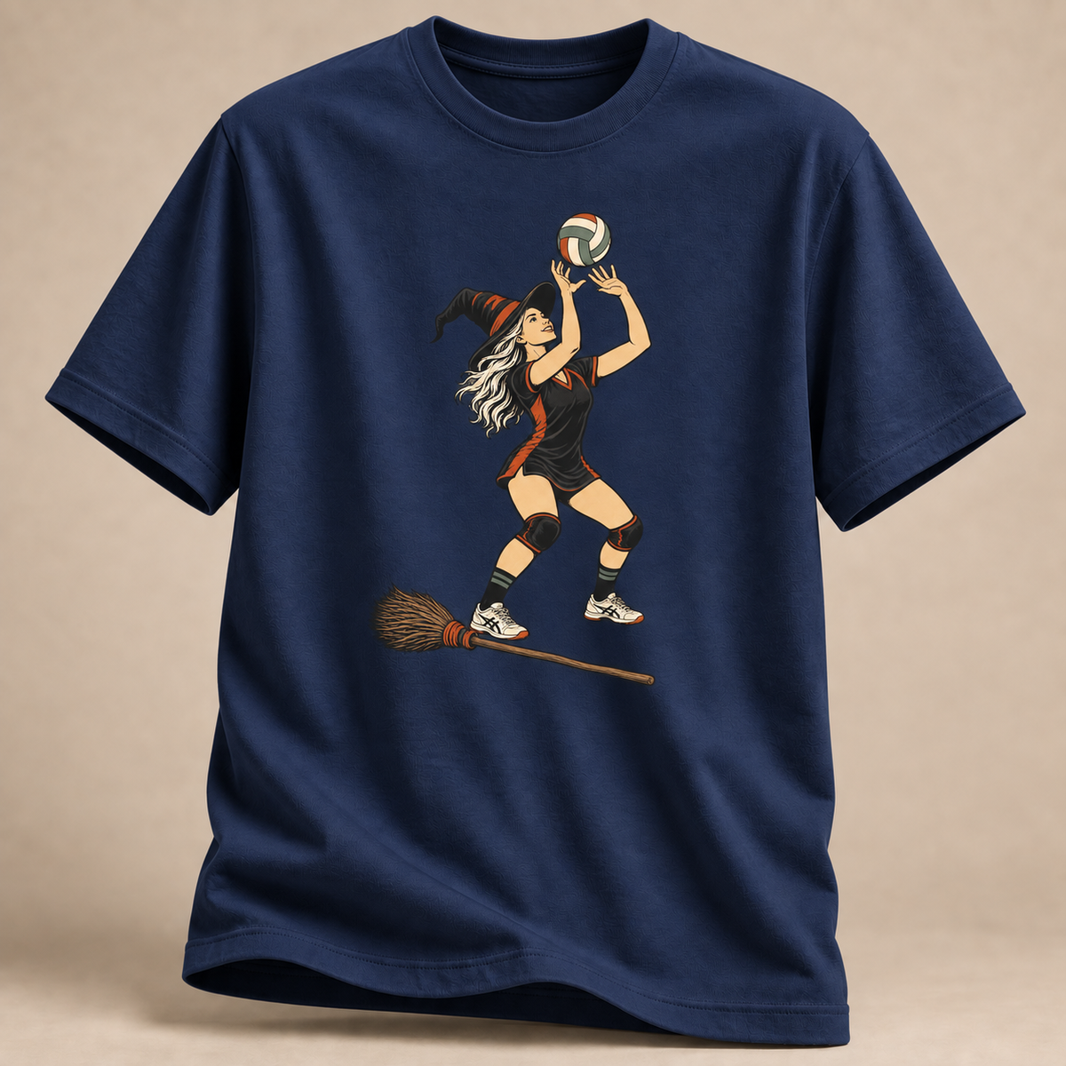 Frontansicht eines marineblauen T-Shirts: Hexe beim Zuspiel mit Volleyball und Besen im Halloween-Motiv.
