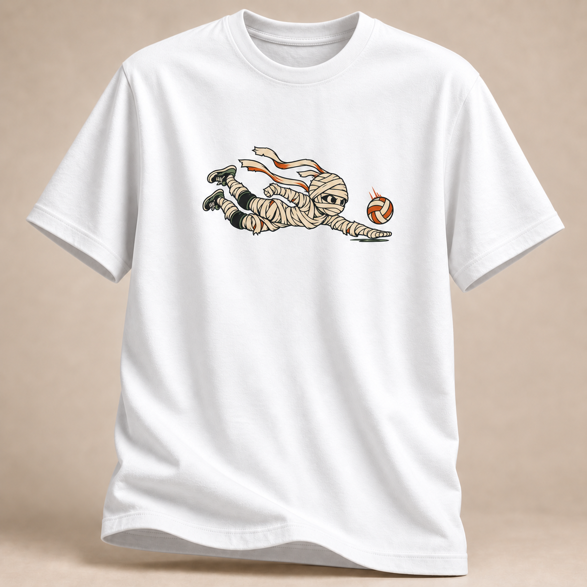 Frontansicht eines weißen T-Shirts: Mumie beim Hechtbagger mit Volleyball im Halloween-Motiv.